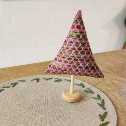 Lille juletræ på rund flakon serviet med grangrene